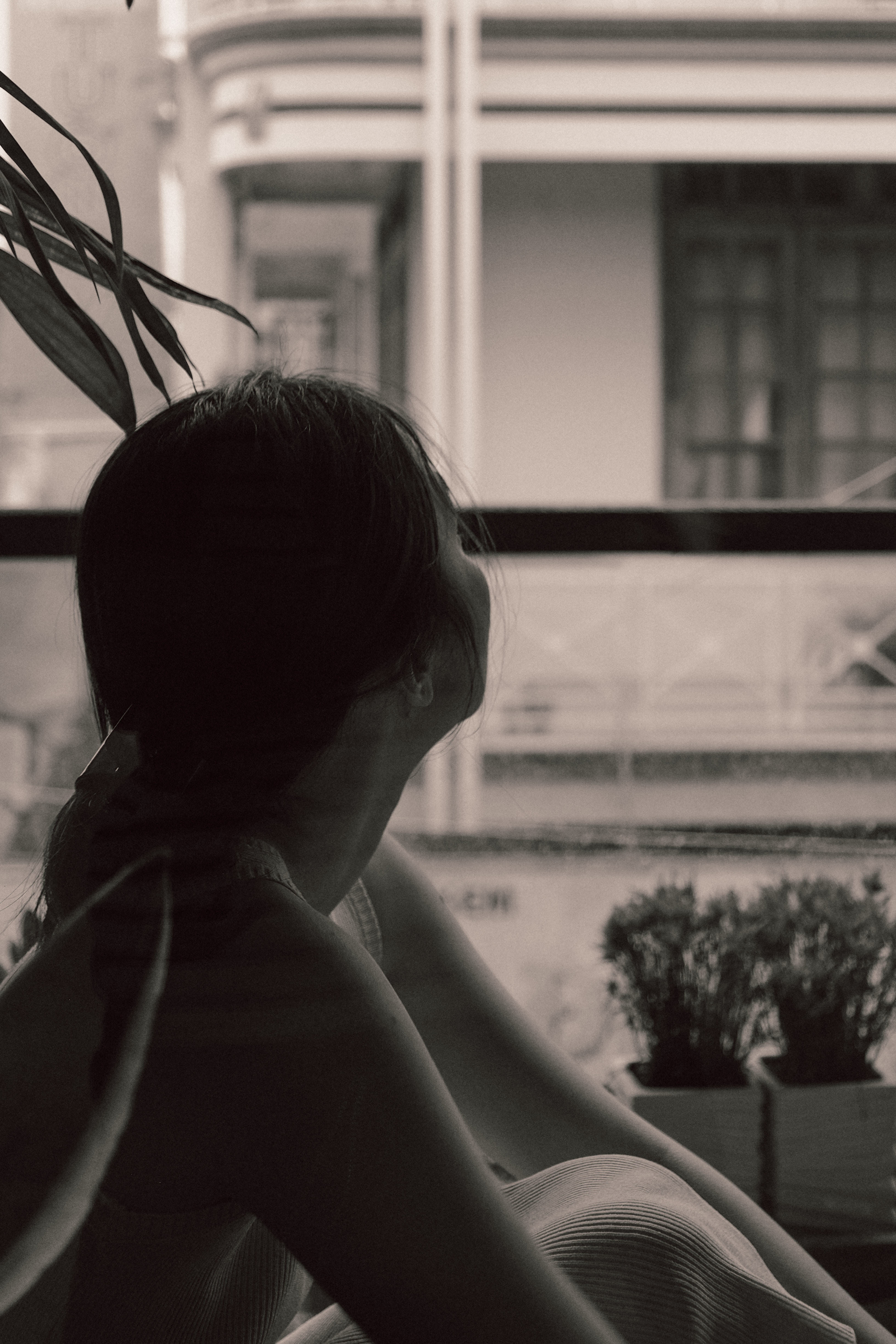 Image of a woman in silhouette looking out a window.